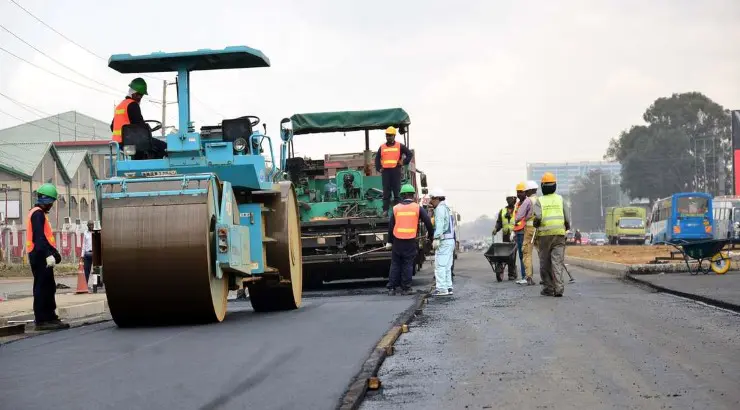 Workers paving a road in Kenya as part of an infrastructure project